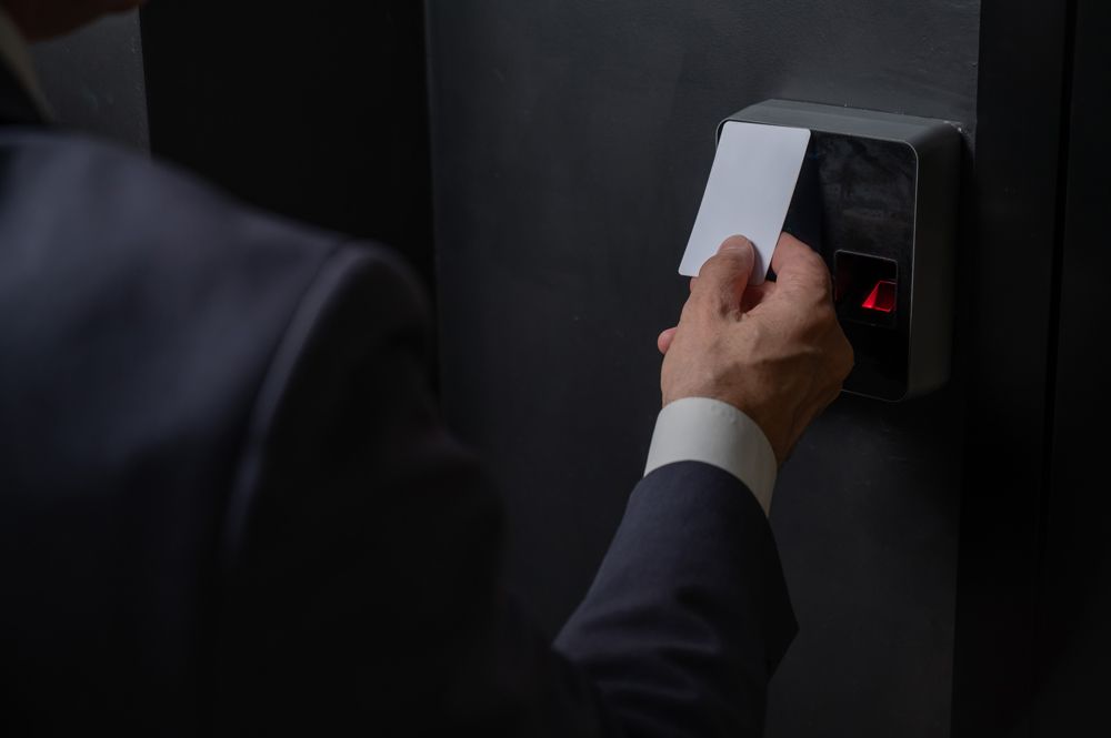 A man in a suit is inserting a card into a door lock.