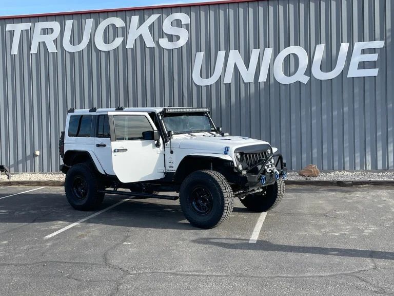 A White Truck With Black Wheels is Parked in Front of Trucks Unique in Albuquerque, NM