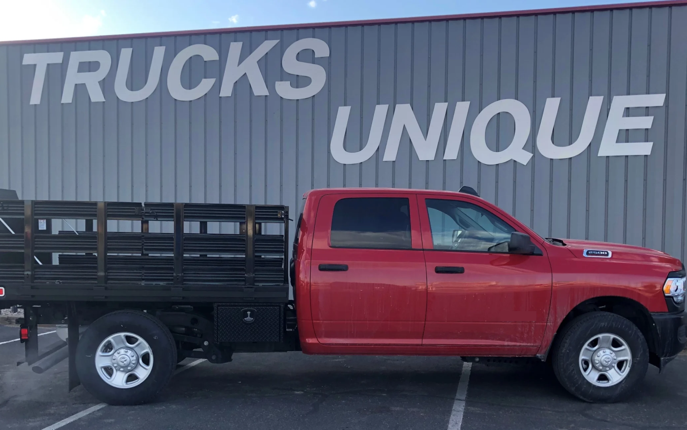 A Red Flatbed Truck is Parked in Front of Trucks Unique in Albuquerque, NM