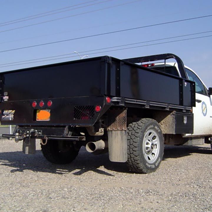 A White Truck With a Black Bed is Parked on Gravel - Truck Unique