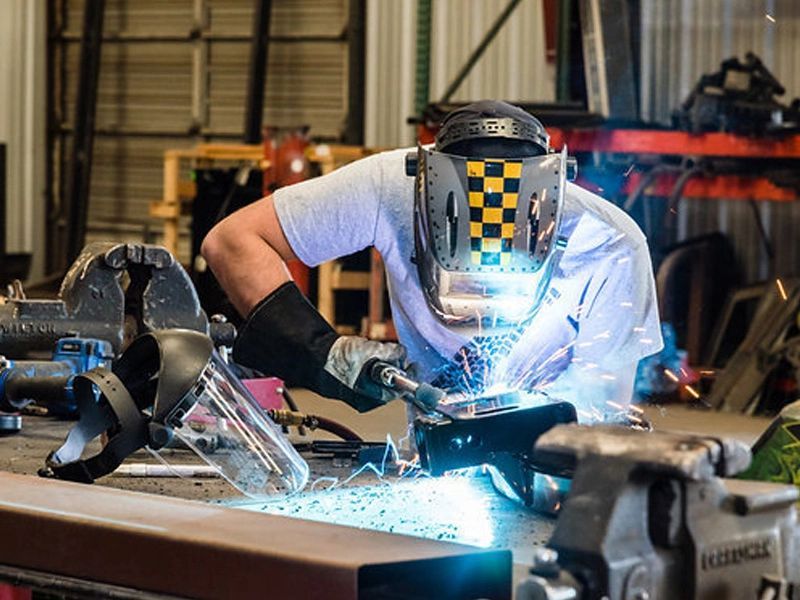 A Man Welding a Piece of Metal at Truck Unique - Albuquerque Truck Parts