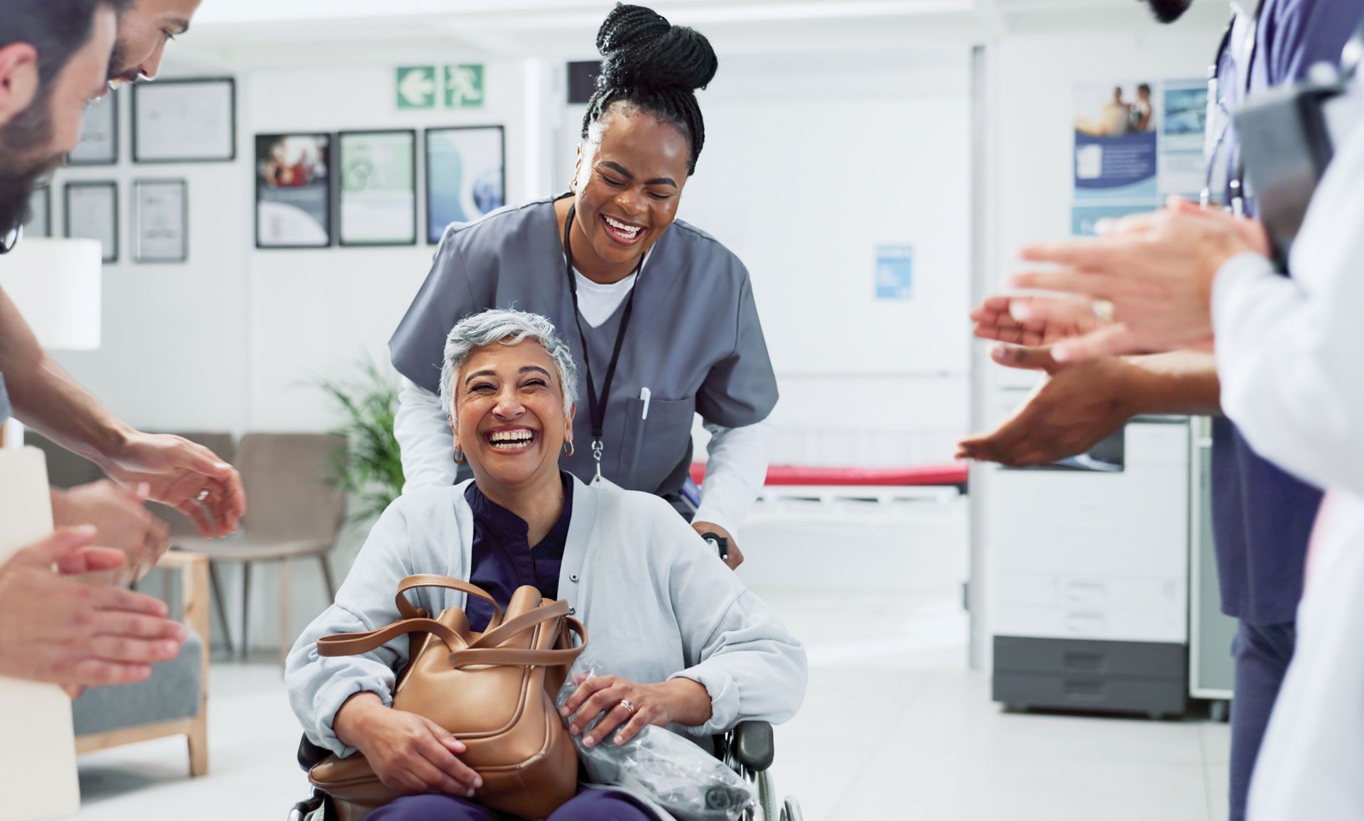 A woman in a wheelchair is being helped by a nurse in a hospital.