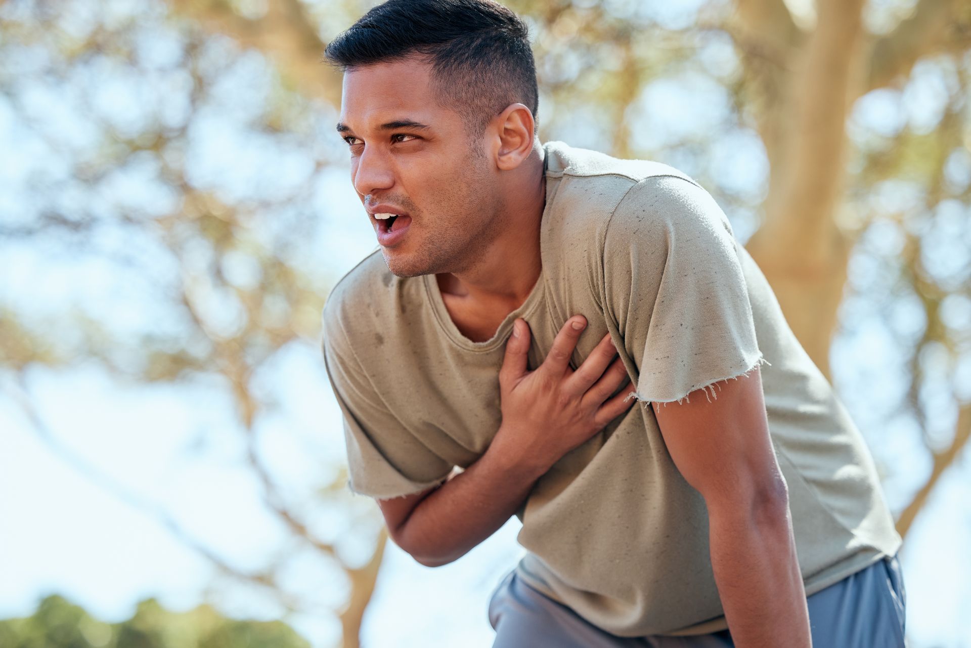 A man is holding his chest because he has a heart attack.