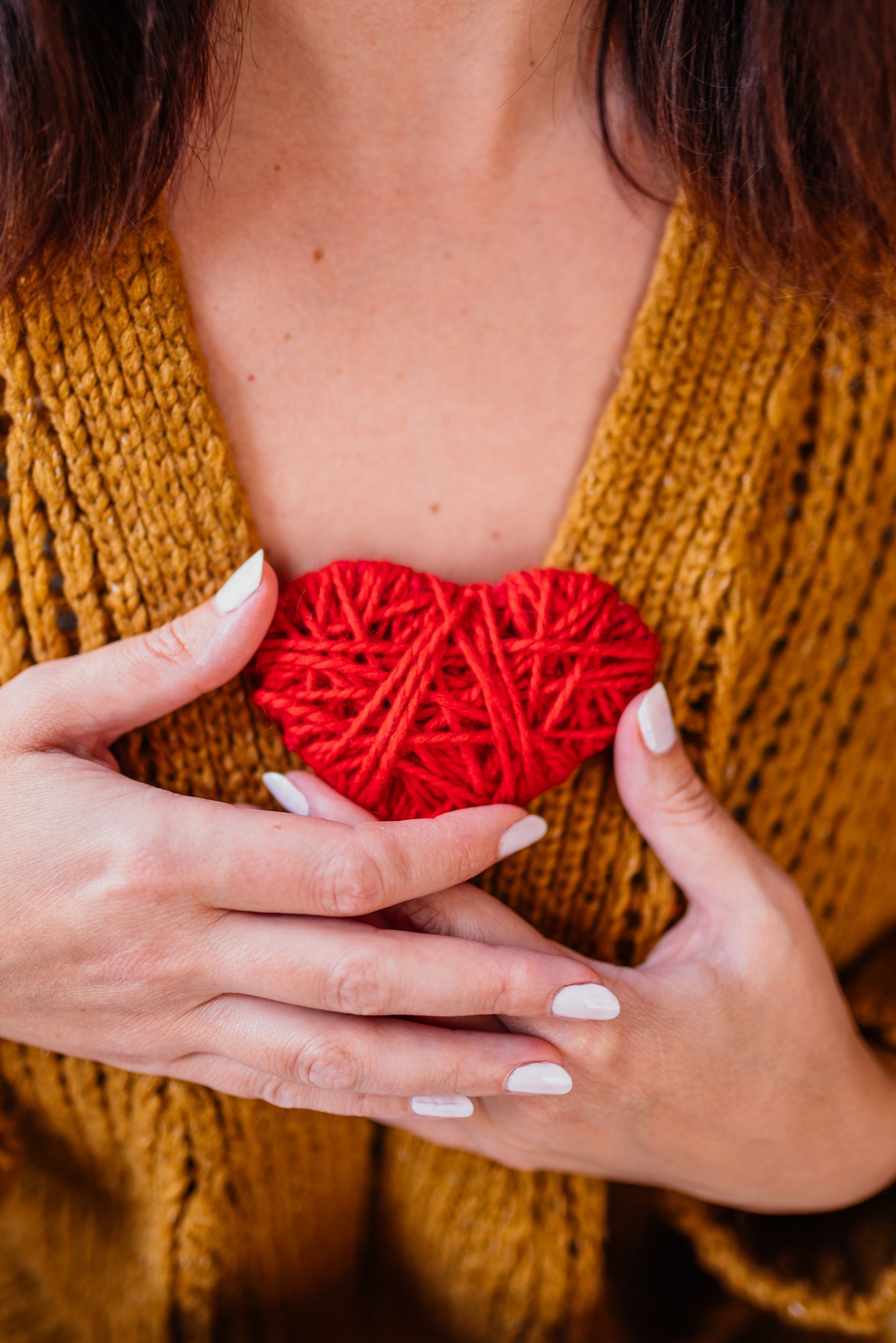 A woman is making a heart shape with her hands.