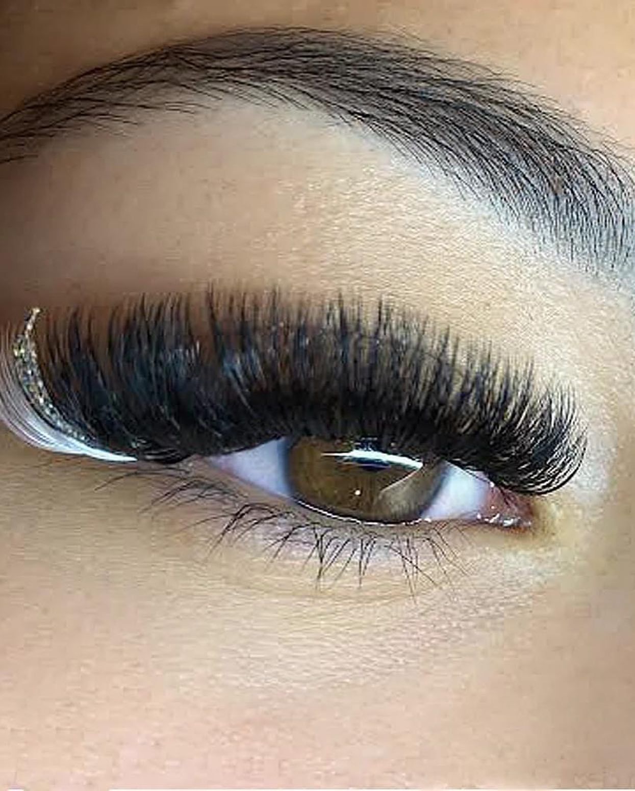 A close up of a woman 's nails with purple glitter and rhinestones