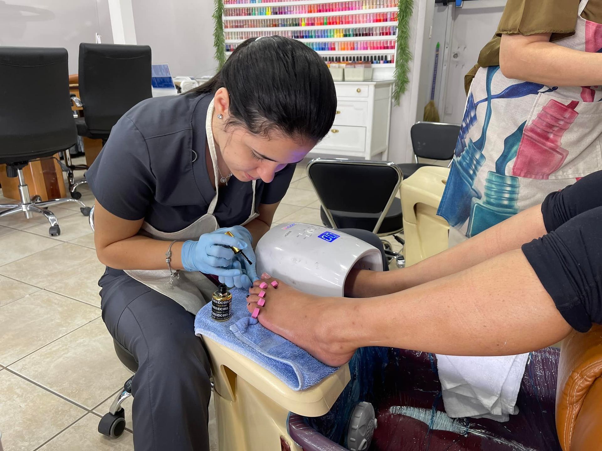 A close up of a woman 's feet and hands with pink nails.