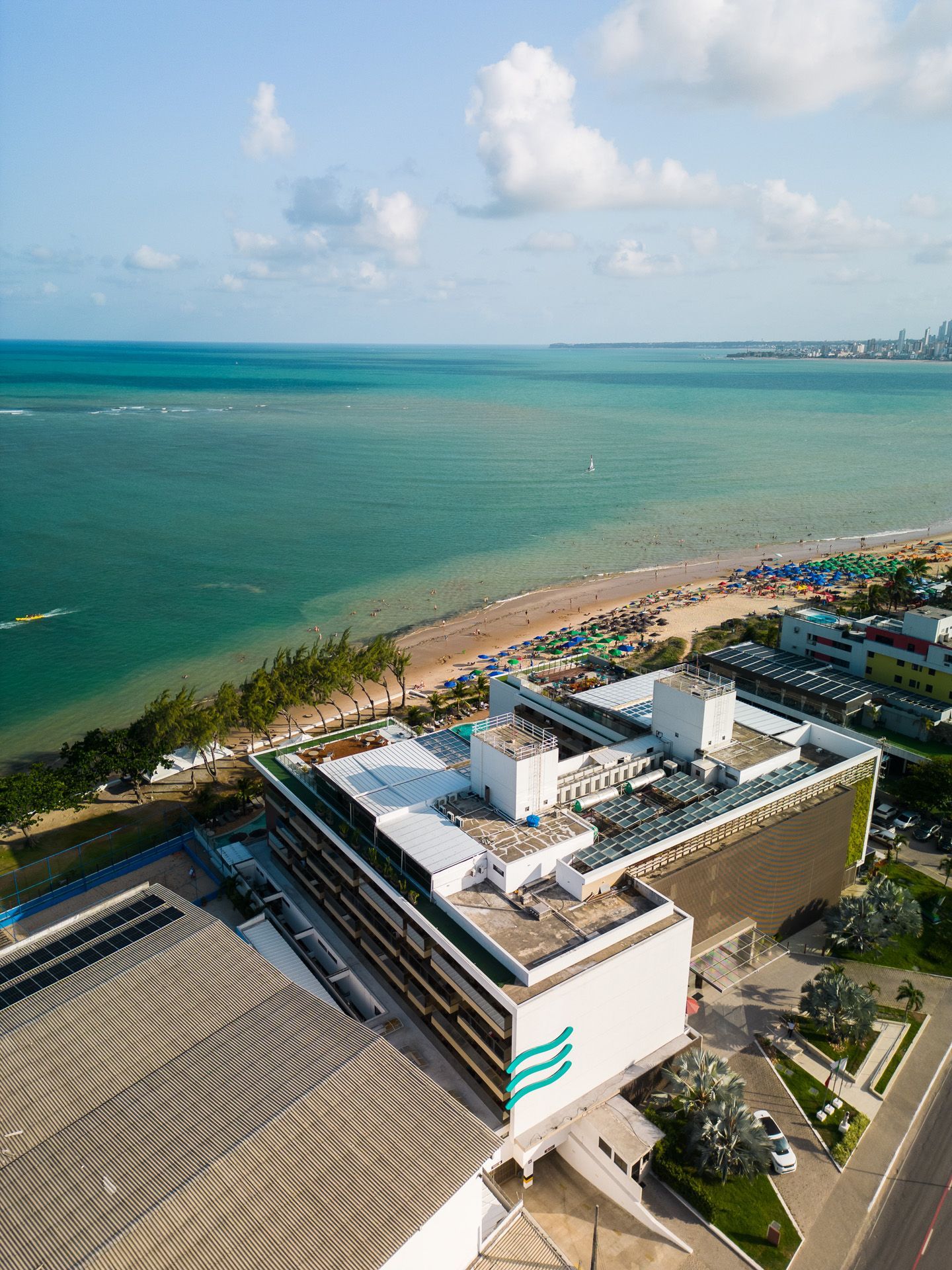 Fileiras de assentos vermelhos vazios em um auditório escuro, iluminados por uma fonte de luz no teto.