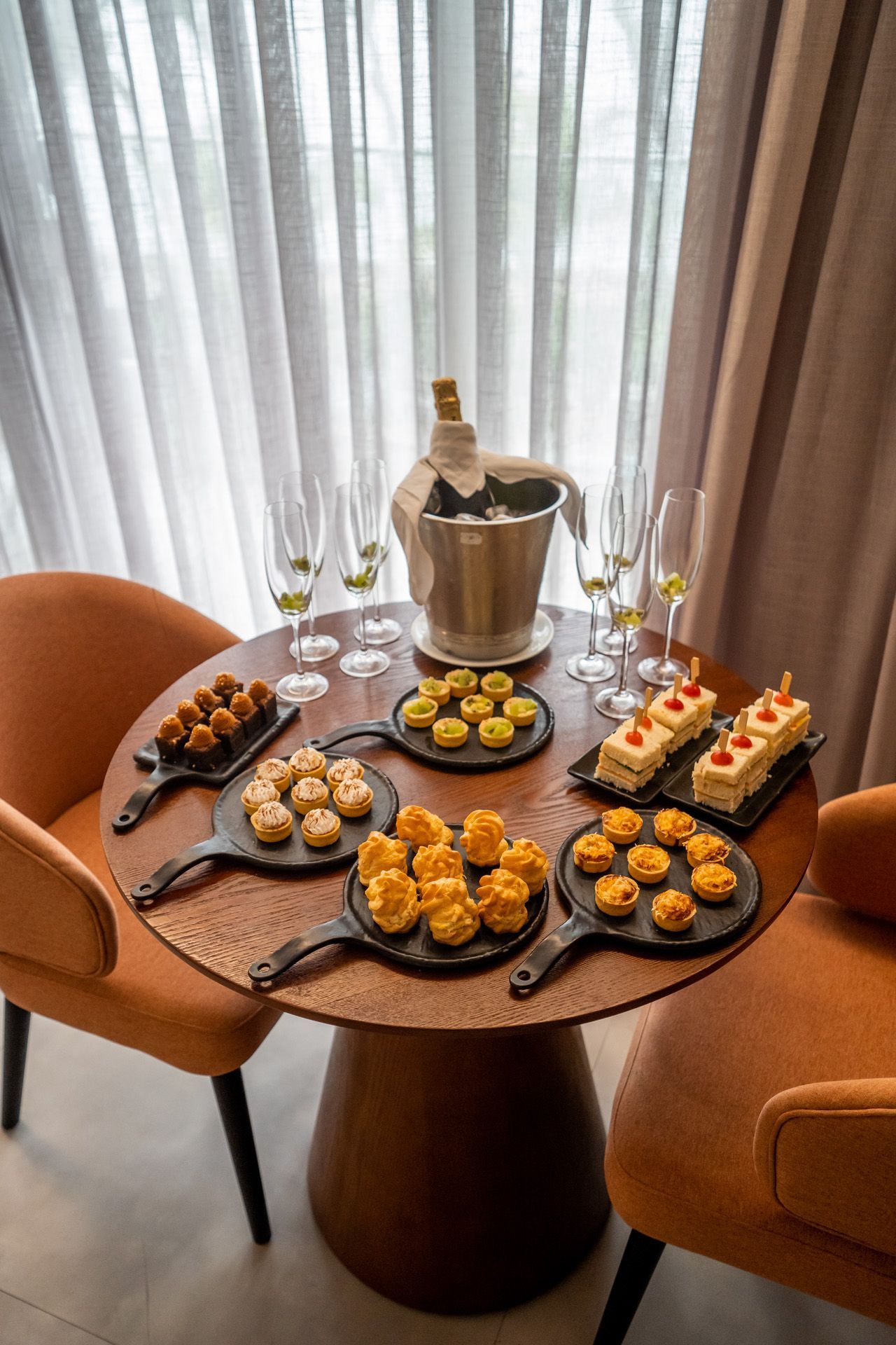 Resort com piscina, vista para o mar e prédio branco de vários andares sob céu azul.