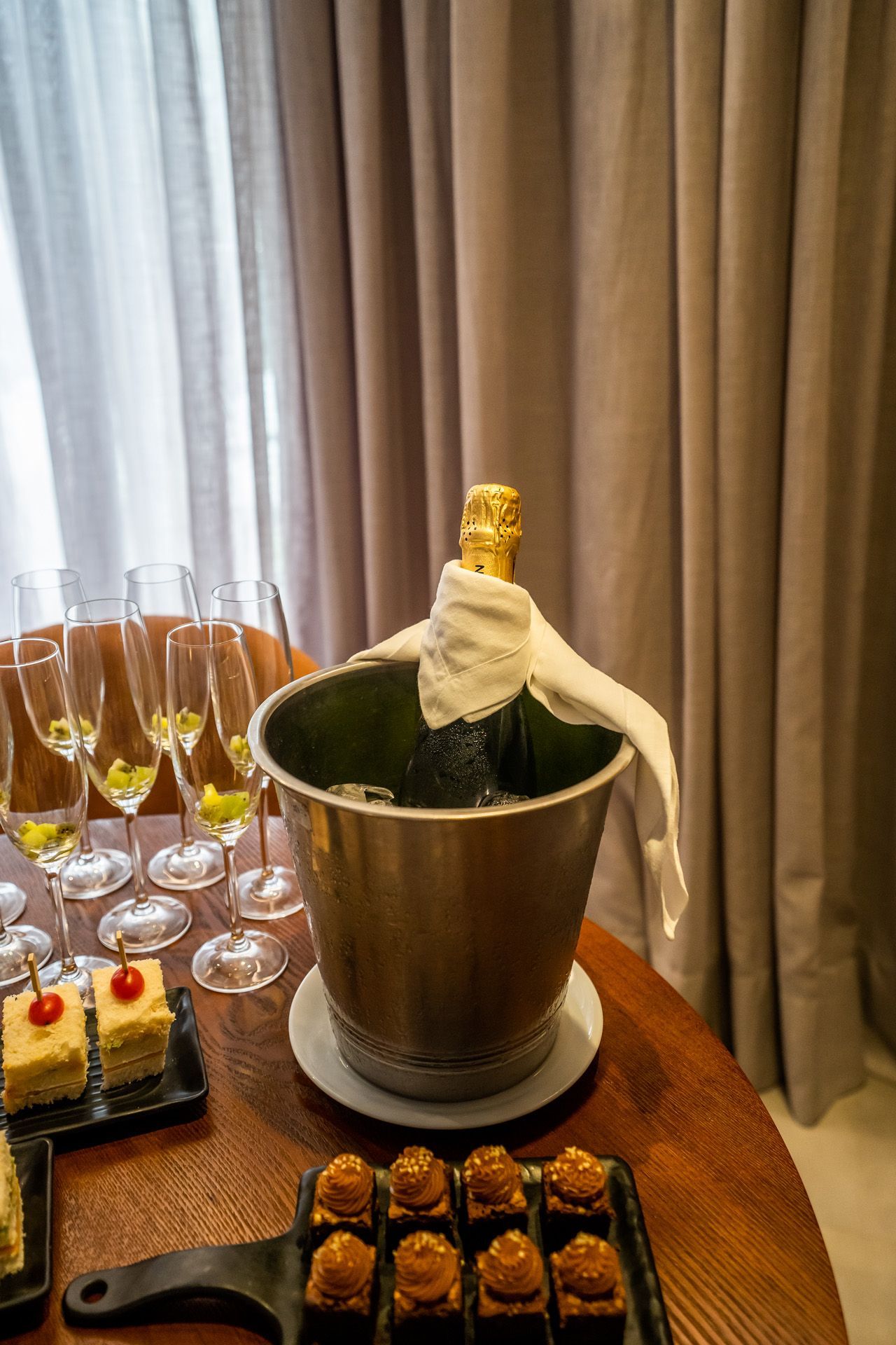 Pessoa recebendo massagem em uma sala de spa com vista para o mar; massagista trabalhando em seus ombros.