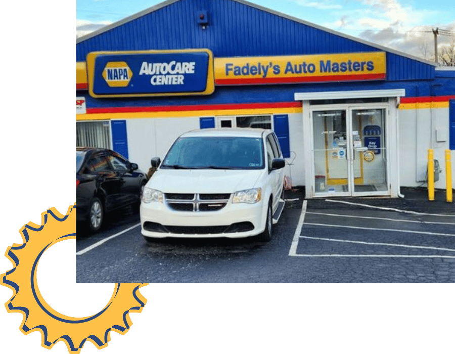 White Dodge minivan parked outside Fadely&rsquo;s Auto Masters NAPA AutoCare Center.