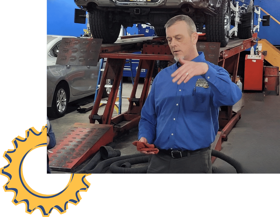 Mechanic inspecting engine components and hoses during exhaust system service.