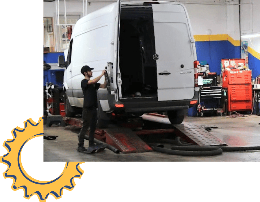 Automotive professional discussing vehicle repairs in a service bay with cars on lifts.