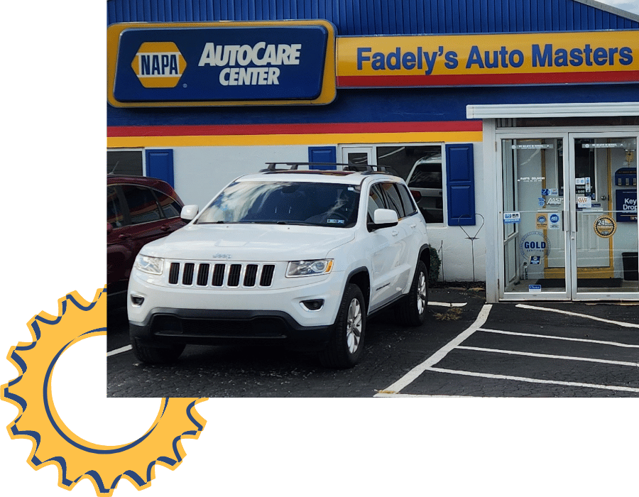 White Jeep SUV parked outside Fadely&rsquo;s Auto Masters storefront.