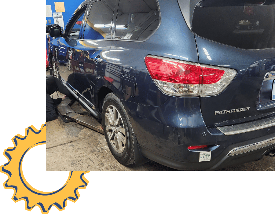 Nissan Pathfinder SUV inside shop during maintenance service.