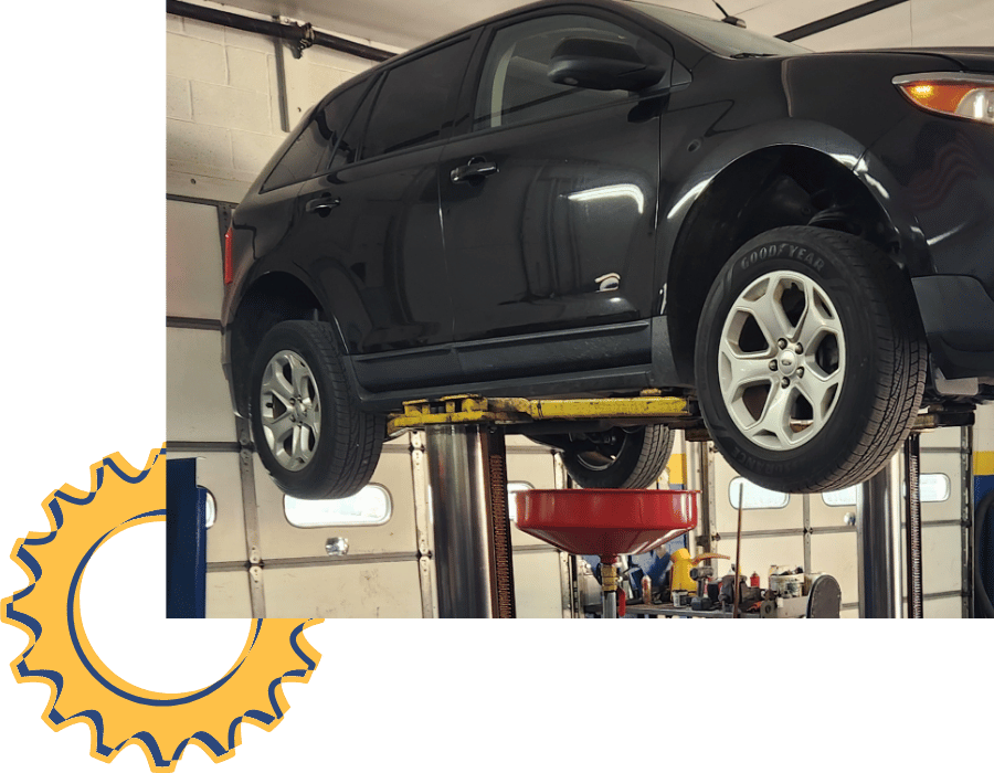 White service van raised on a lift for routine maintenance and oil change service.