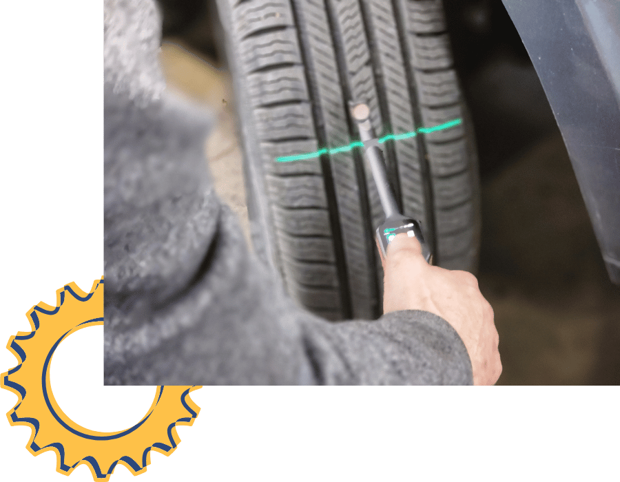 Mechanic measuring tire tread depth during tire inspection service.