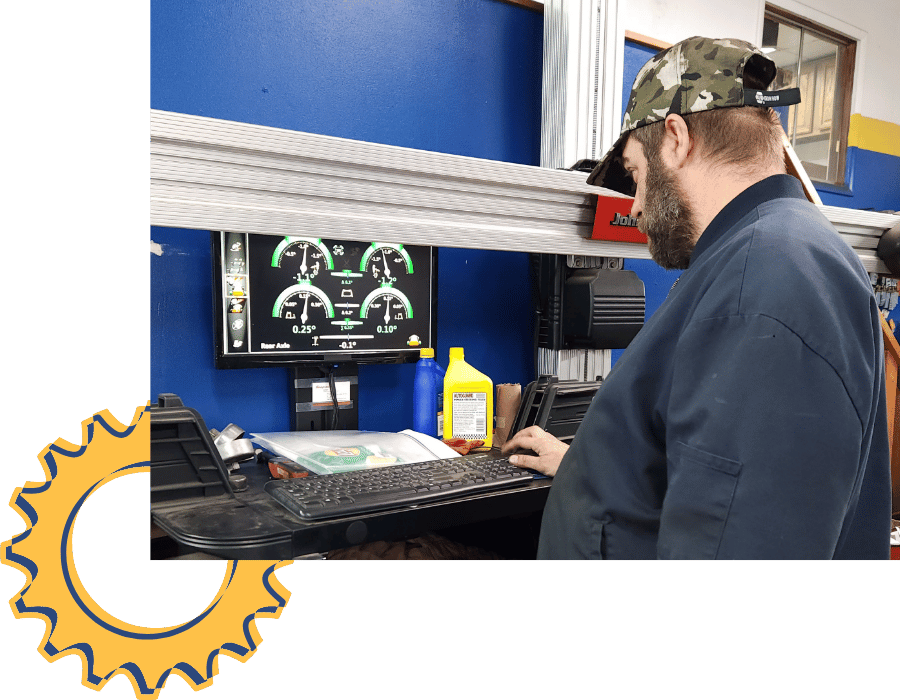 Mechanic conducting a tune-up and engine service with hood open in repair bay.