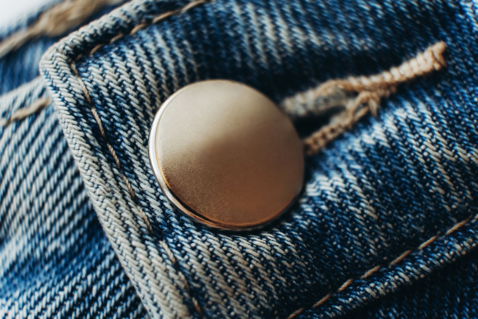 Primo piano di un bottone di un paio di jeans.