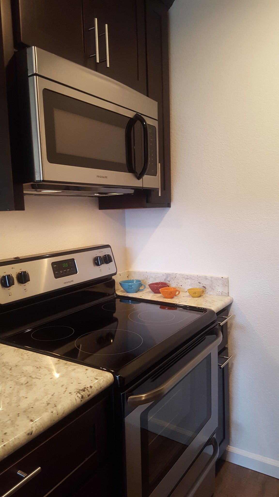 A kitchen with a stove , microwave , and oven.
