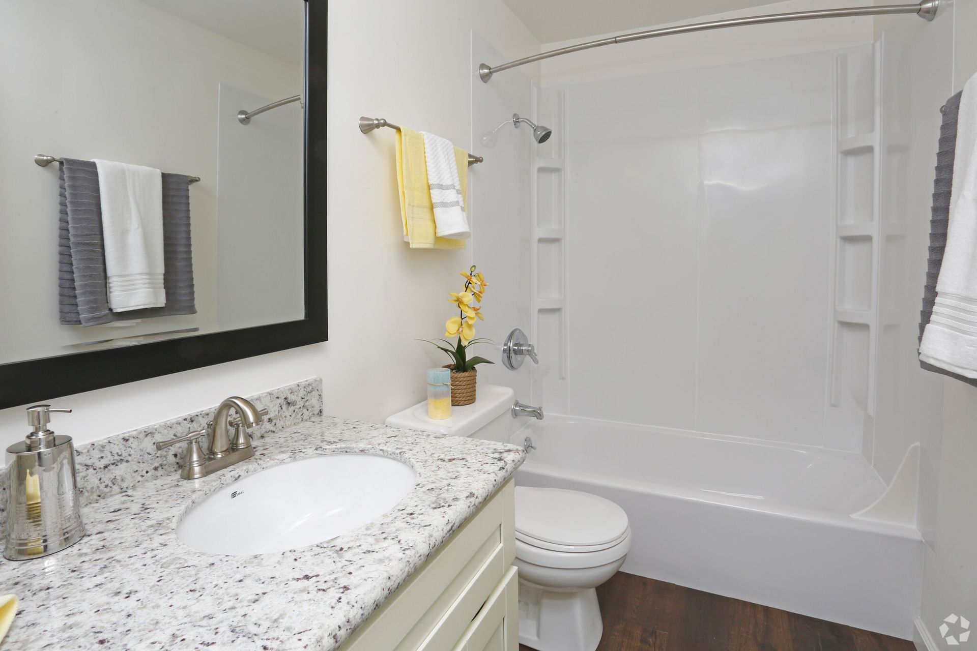 A bathroom with a sink , toilet , bathtub and mirror
