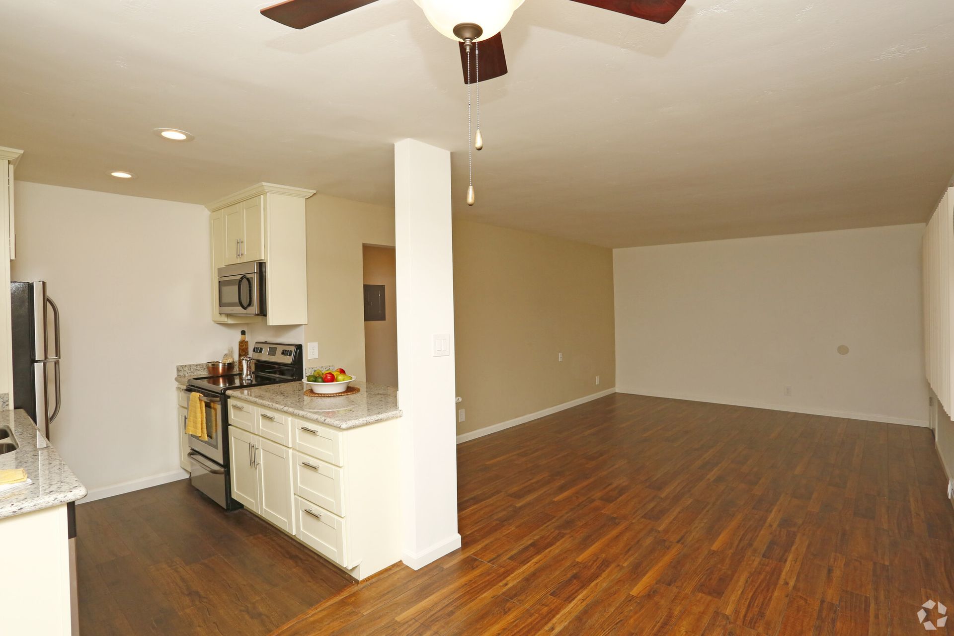 A kitchen with stainless steel appliances and a ceiling fan