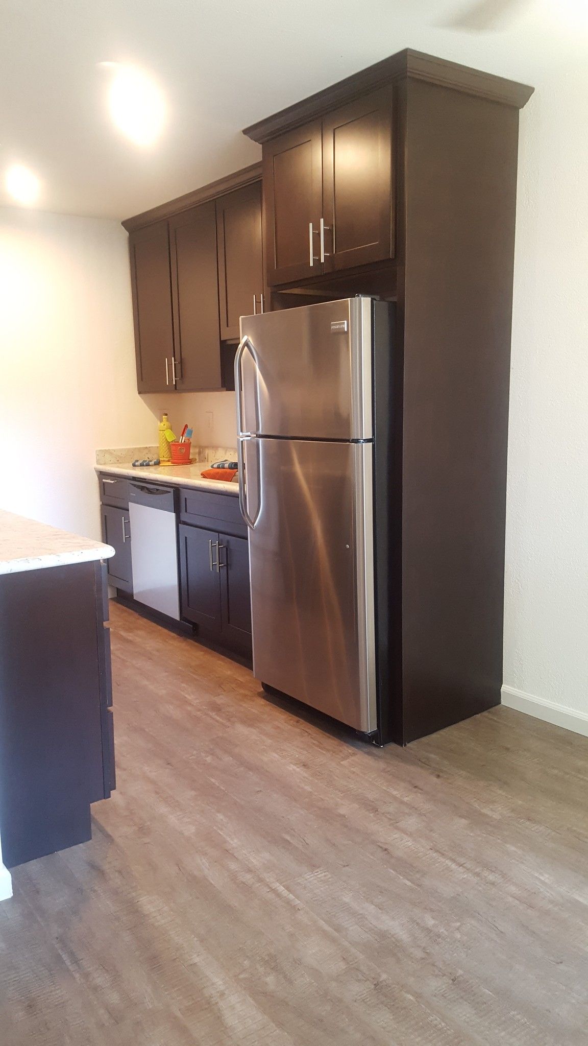 A kitchen with stainless steel appliances and wooden floors.