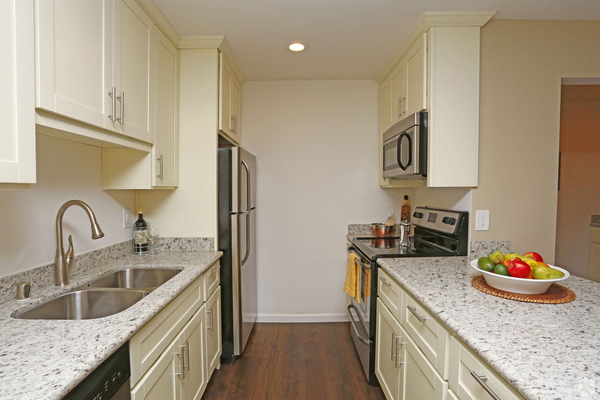 A kitchen with white cabinets stainless steel appliances and granite counter tops