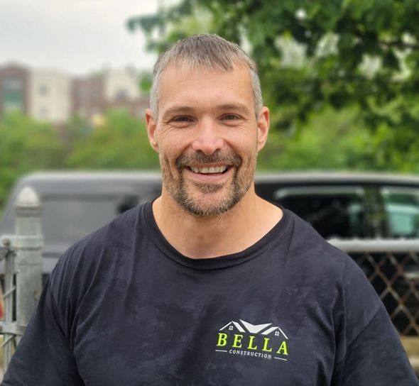 A man wearing a bella t-shirt is smiling for the camera