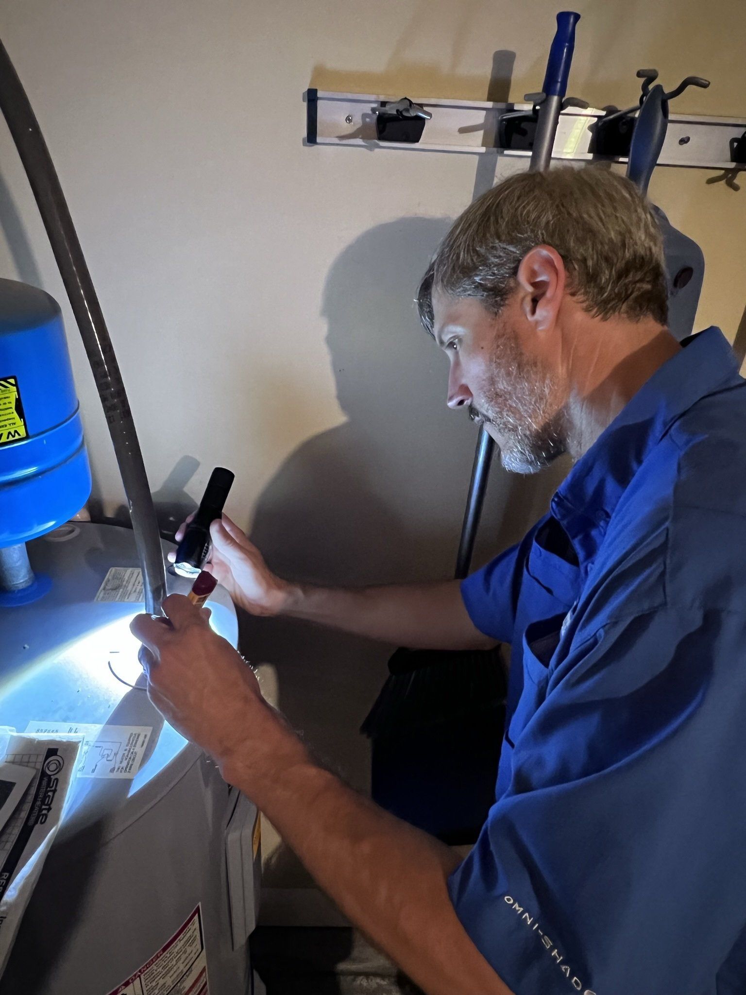 A man in a blue shirt is working on a machine