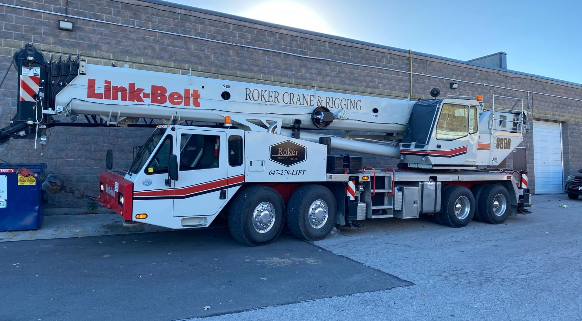 A large crane is parked in front of a building.
