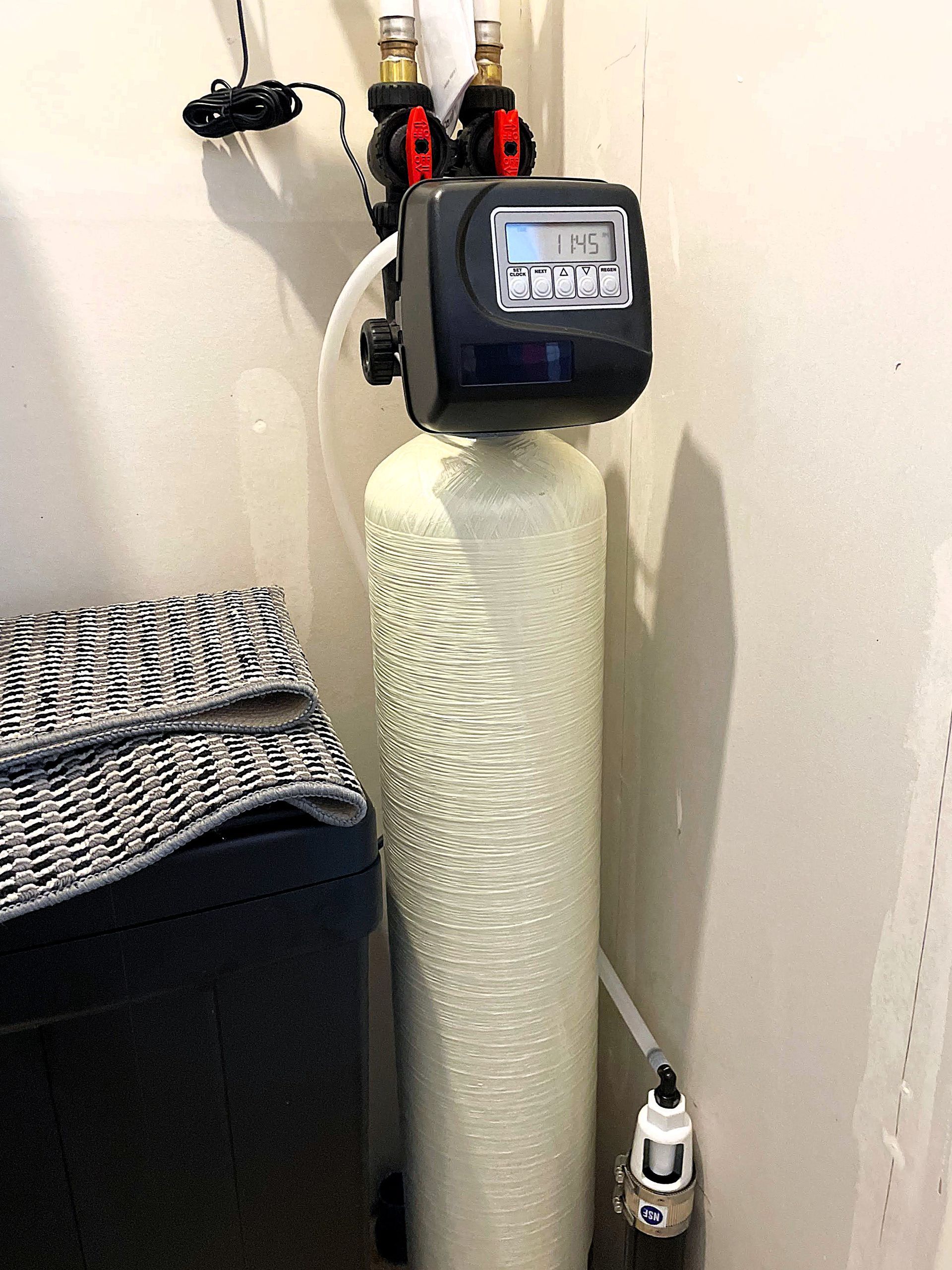 Sharp Water Solutions installing efficient water softener in Bluffdale UT residential utility closet for scale prevention