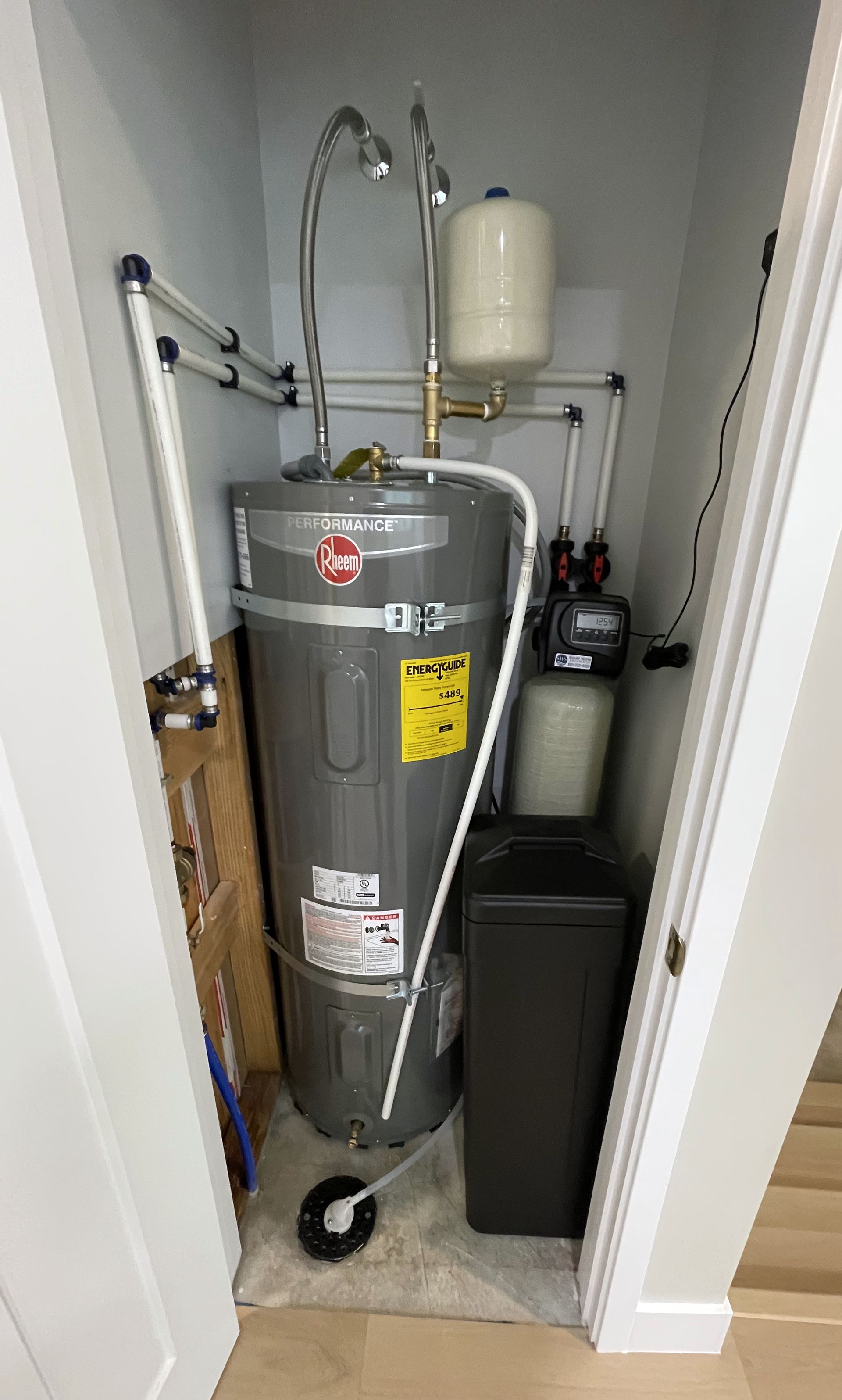 Sharp Water Solutions installing efficient water heater in Salt Lake County utility closet for reliable hot water.