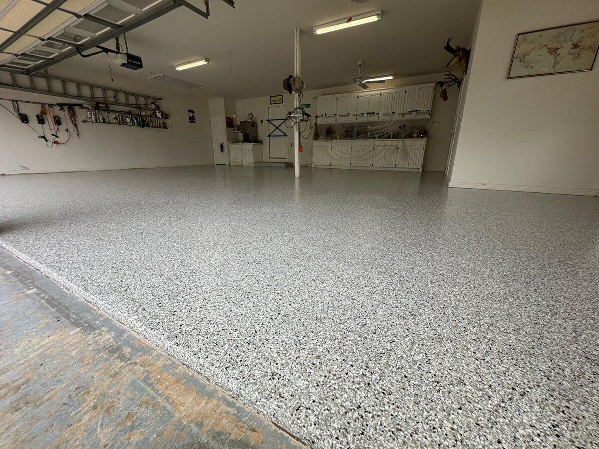 Garage with a gray speckled epoxy floor and white walls.