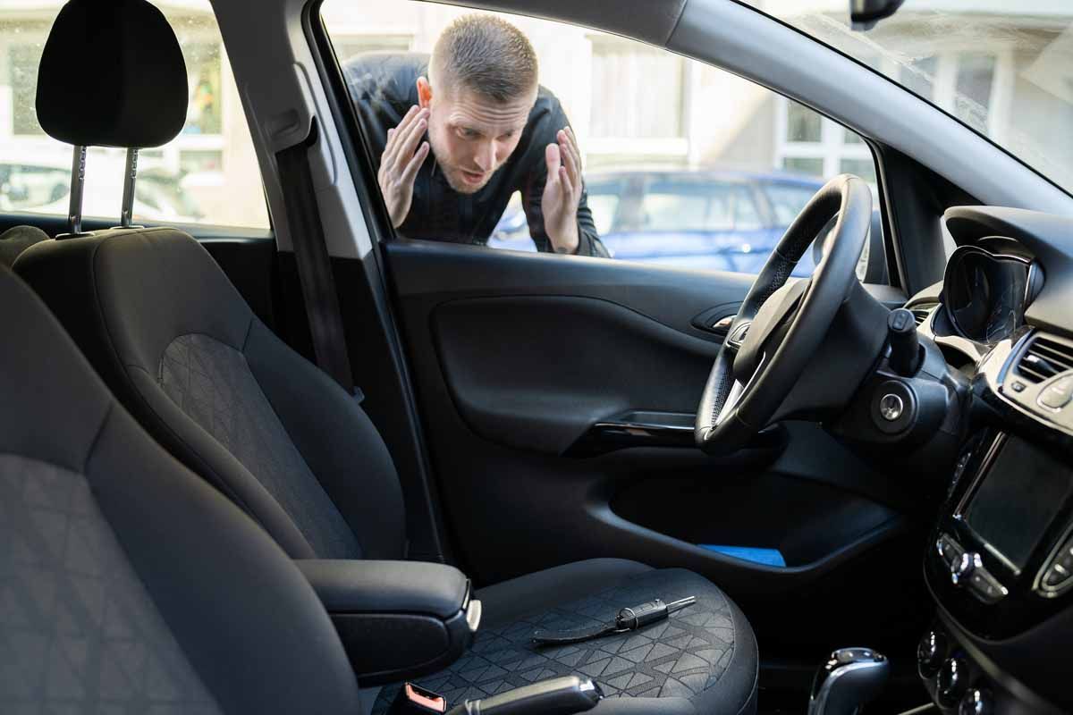 A man is looking through the window of a car.