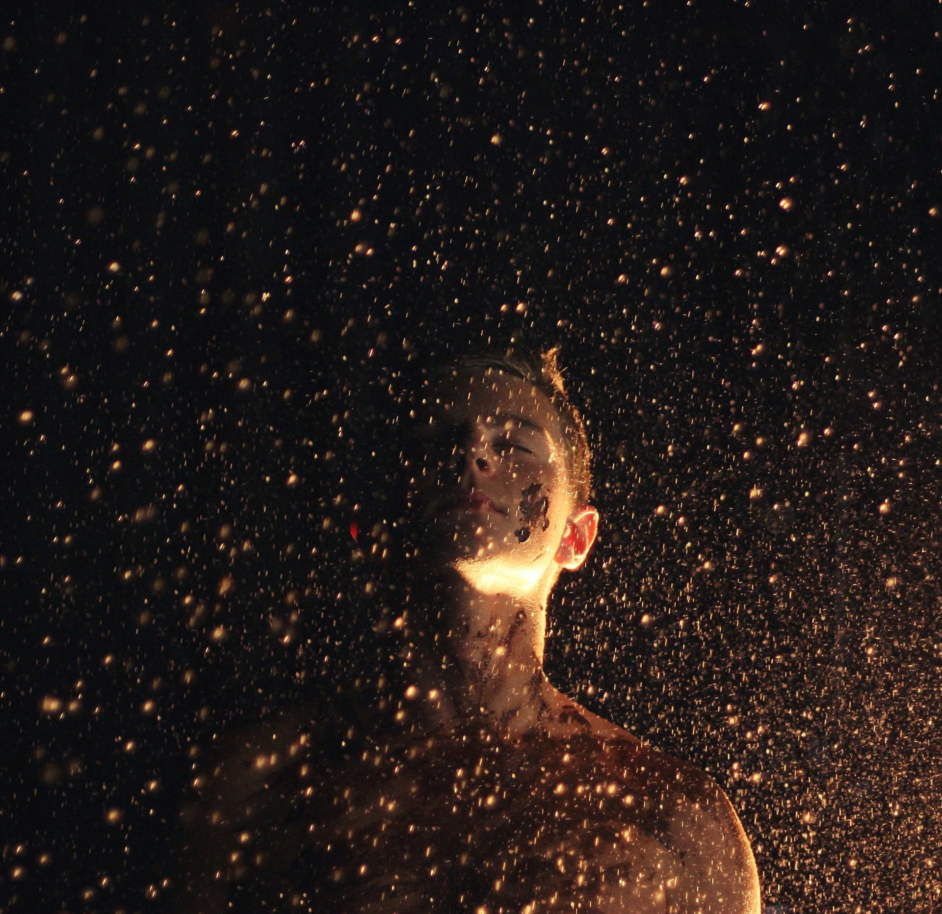 a person 's face is covered in sparkles in the dark