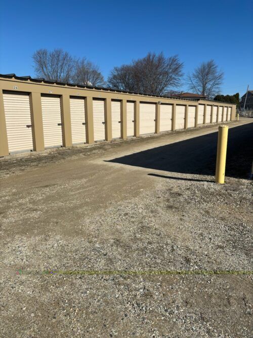 Row of beige storage units under a clear blue sky.