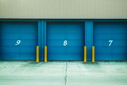 Blue storage unit doors numbered 9, 8, and 7, with yellow posts.