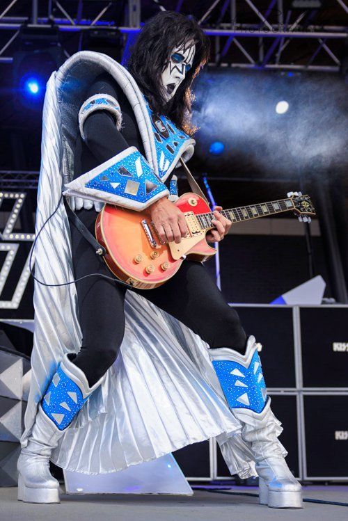 a man in a kiss costume is playing a guitar on stage