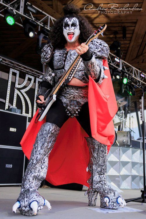 a man in a kiss costume is playing a guitar on stage