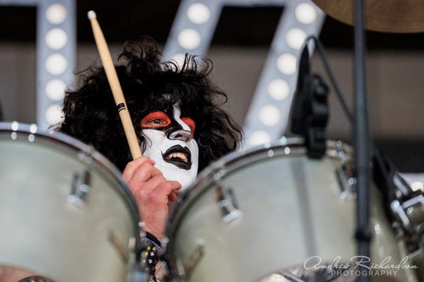 a man with a mask on his face is playing drums