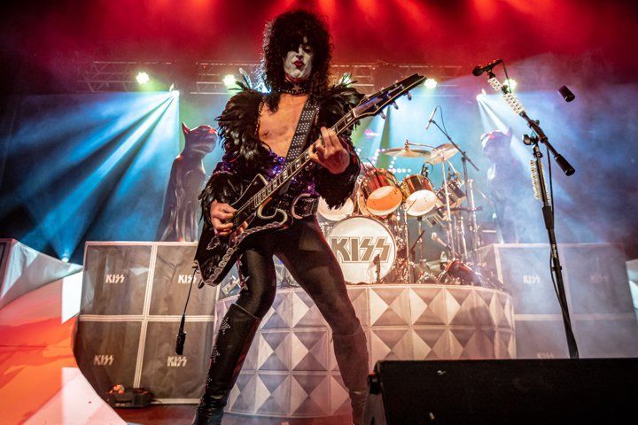 a man is playing a guitar on a stage in front of a microphone .