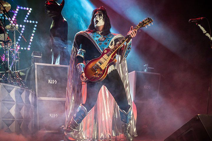 a man in a mask is playing a guitar on a stage .