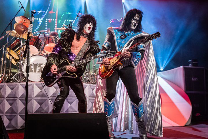 two men are playing guitars on a stage in front of a microphone .