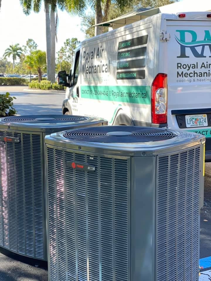 Two air conditioners are parked in front of a van.