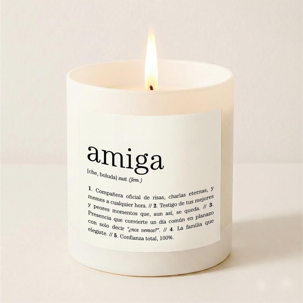 Vela blanca perfumada con la etiqueta “amiga” y una llama encendida sobre un fondo claro.