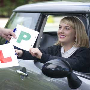Female driver swapping her L Plate for a P Plate