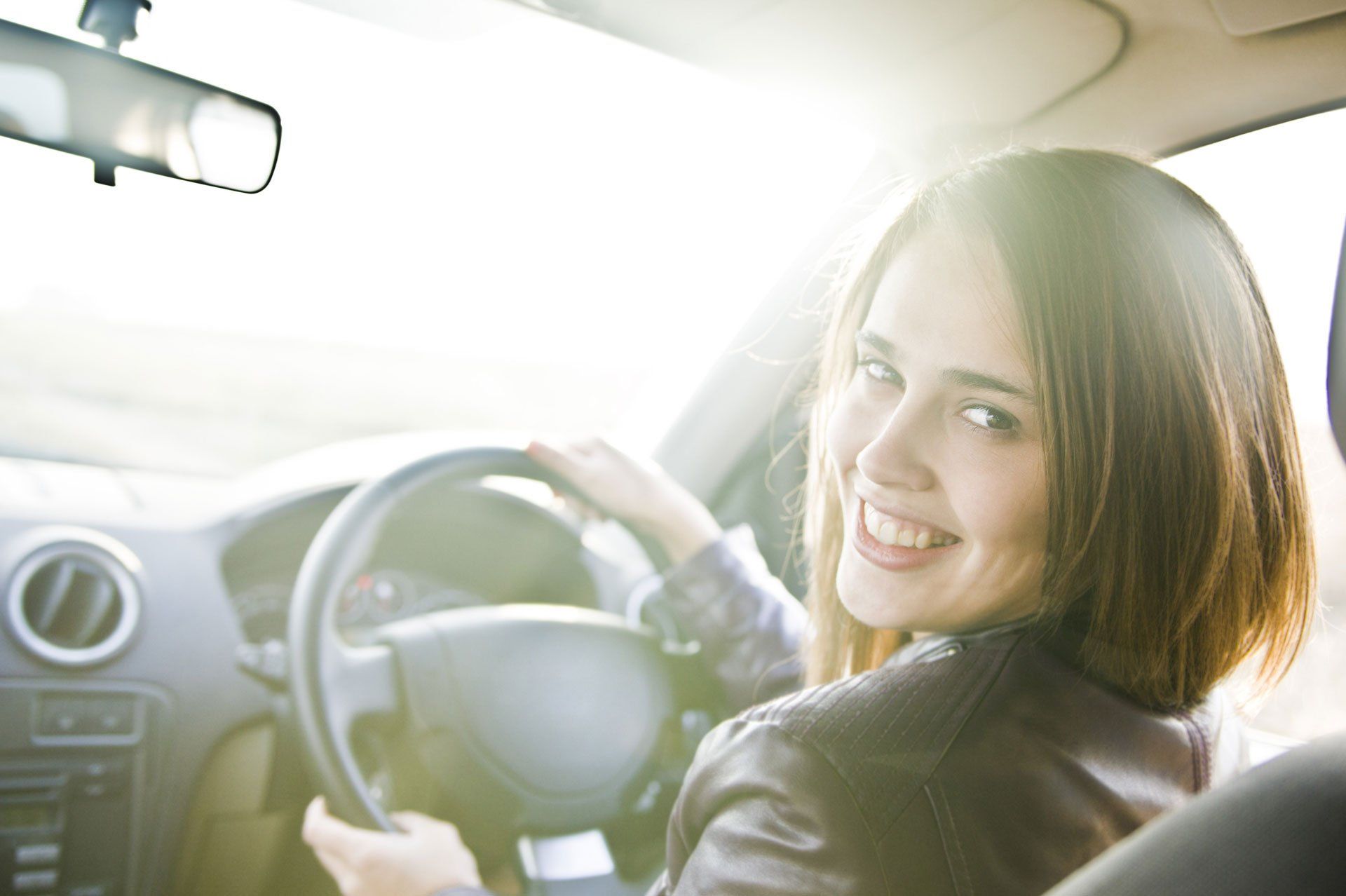 Smiling female driver at steering wheel