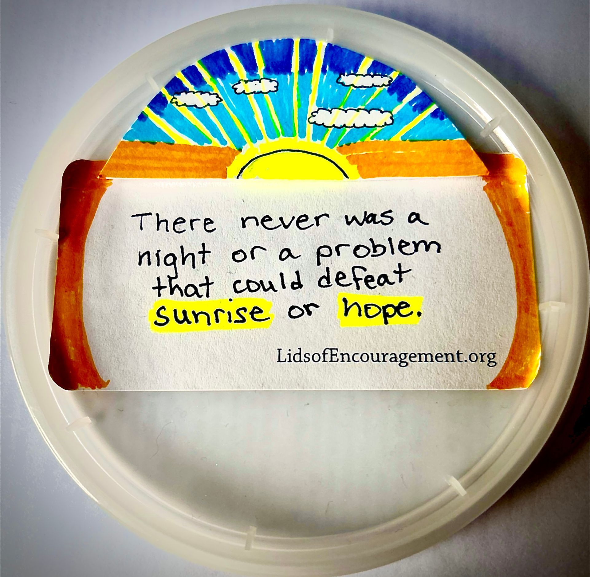 A paper plate with a note that says there never was a night or a problem that could defeat sunrise or hope