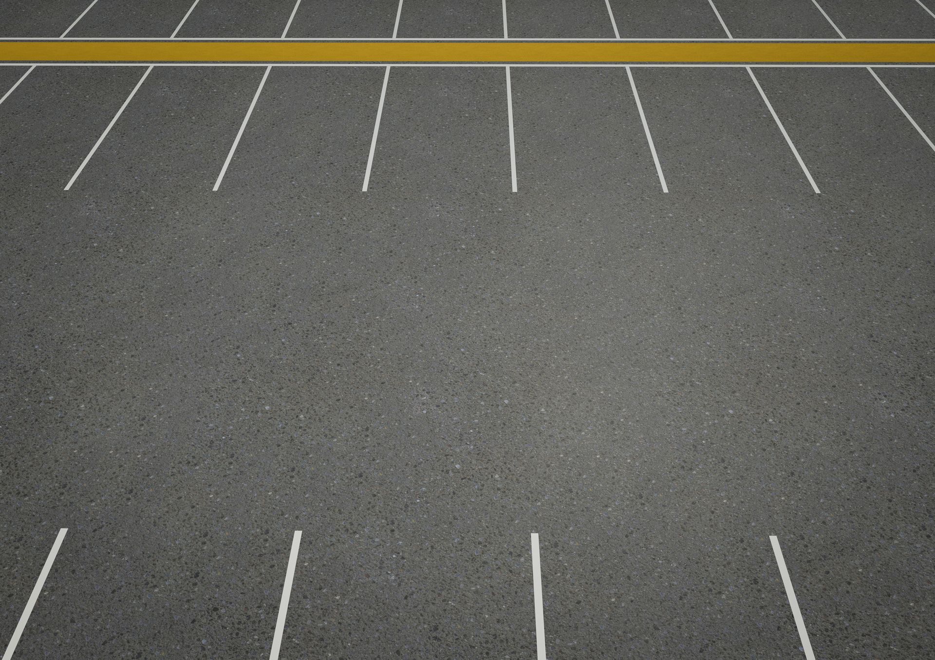 An empty parking lot with white lines and a yellow divider, no cars or people, and clean pavement