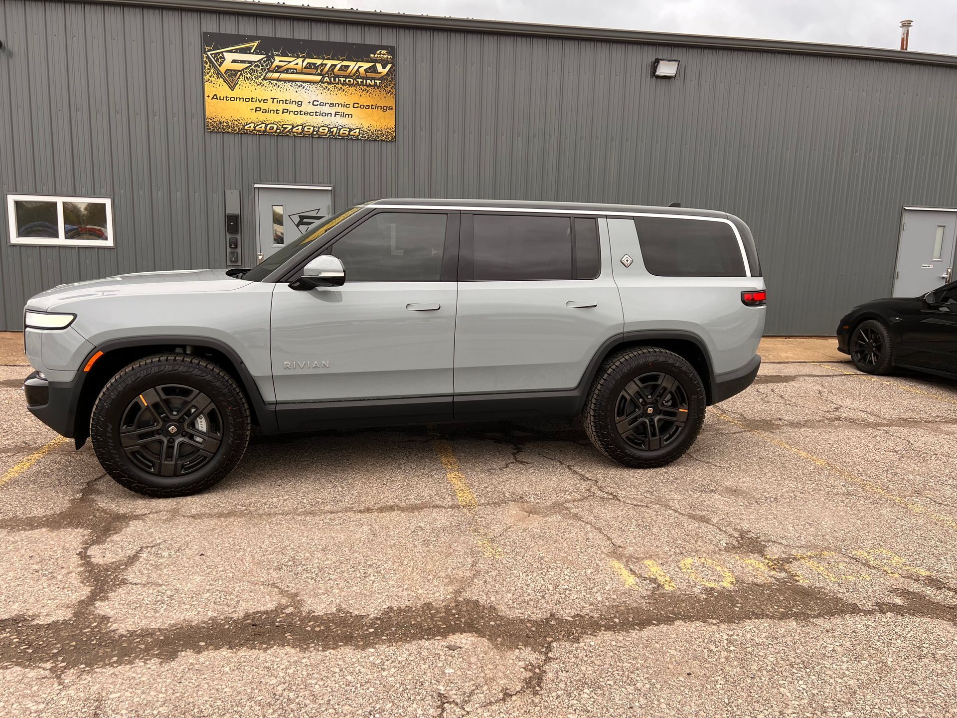 A gray suv is parked in front of a building.